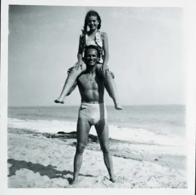 Niels Bagge på stranden med Julia på skuldrene