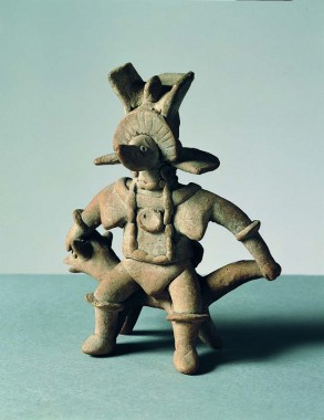 Mand i ceremoniel klædedragt, med dyremaske, stor hovedbeklædning og store smykker, siddende på en dyretrone, højde 15 cm, Colima/det sydlige Jalisco. Sen Comalastil, ca. 300 e.Kr.