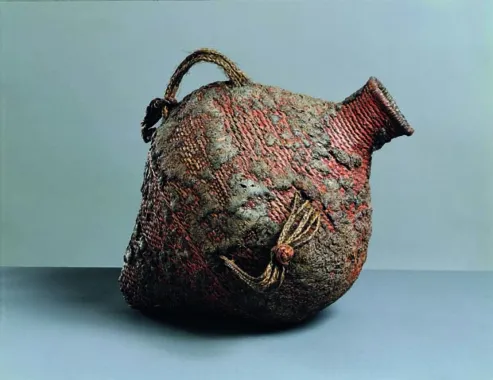 Vandkrukke flettet af plantefibre og tætnet med harpiks, hanke af hår. Højde 42 cm.