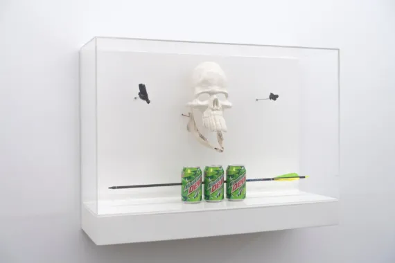 Archer, 2023. Soda cans, arrow, caribou jaw, fimo clay, aegerine stone, lava stone, vitrine. Foto: Martin Brandt Hansen