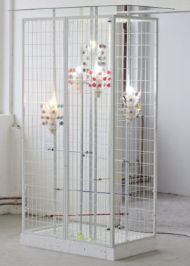 Hotproducts, 2015. Styrofoam, Dunlop tennis ball, steel with epoxy/polyester powder coating, Original Gourmet Lollipop, lollipop tree display, plastilin, plastic strips, cord, energy-efficient light bulb, elastic bungee. Installation view: Rundgang, Städelschule, Frankfurt. Foto: Benedikte Bjerre