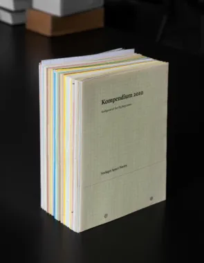 A5 hæfter med meget forskelligt indhold. Kompendium betyder en samling af noget, der er det samme og hvert hæfte har sit eget emne. Serien er påbegyndt 2010 og har nu 47 numre. Billeder og tekster af Åse Eg Jørgensen. Materialer: Laserprint i sort på A4 papir, fortrykt, hvidt eller farvet, håndsyet, oplag ca. 40-80 stk. Foto: Johan Rosenmunthe
