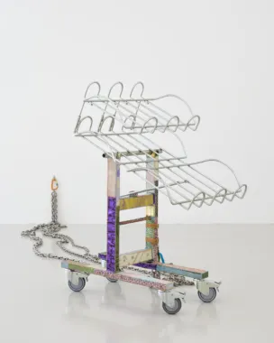 Maiken Bent, Fixtures #3, 2022. Brugt frugtstativ på hjul, skindrester fra modeindustrien, læder, vokset tråd, spænder, kæder, ringe, karabinhager, vægkrog. 120 x 64 x 97 cm + kæder. Foto: Brian Kure.