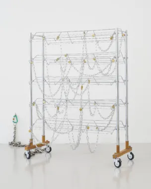 Maiken Bent, Fixtures #7, 2022. Skostativ på hjul, læder, skind, vokset tråd, spænde, kæder, hængelåse, ringe, karabinhager, vægkrog. 145 x 115 x 49 cm + kæde. Foto: Brian Kure.